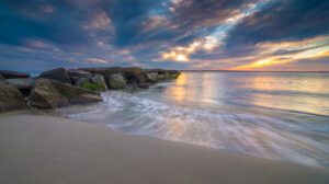 The tide at a beach at sunset showing the ebb and flow of the sea.