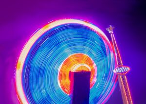 Continuous bands on light on a moving Booster fairground ride. The circular movement represents Continuous Strategy.